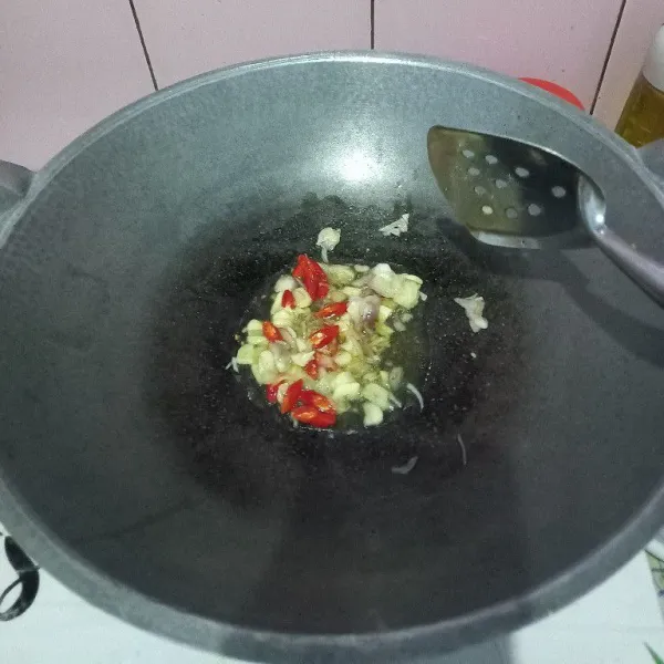 Tumis bawang merah, bawang putih, dan cabe merah hingga harum dan matang.