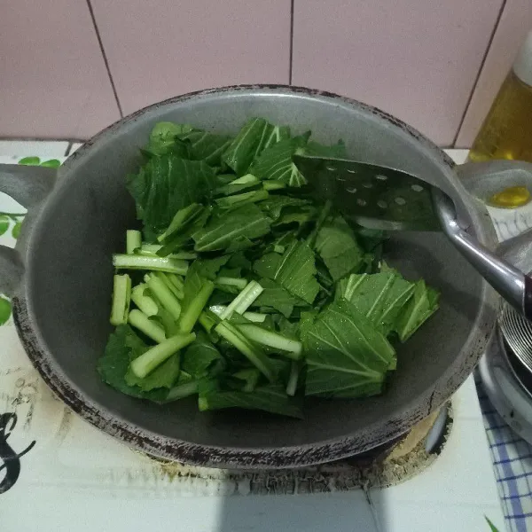Masukkan caisim, aduk rata dan masak hingga setengah layu.