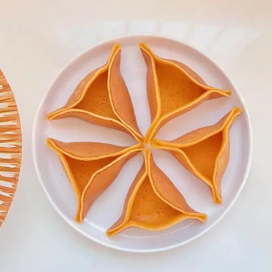 Angkat pancake setelah permukaannya muncul gelembung kecil. Lipat pancake menjadi bentuk segitiga