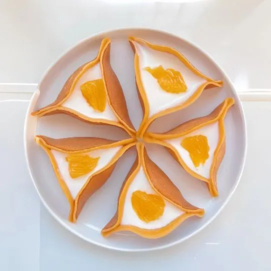 Tambahkan isian yoghurt di dalam lipatan segitiga. Tambahkan potongan jeruk mandarin sebagai topping