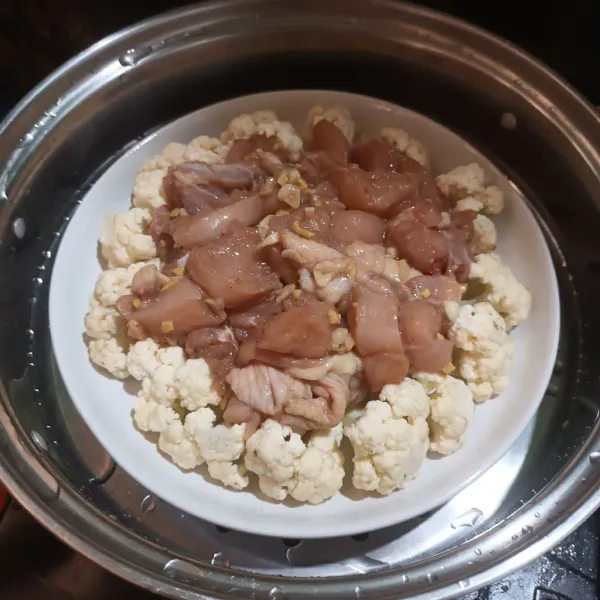 Lalu tambahkan ayam di atas kembang kol. Kukus kurang lebih 15-20 menit.