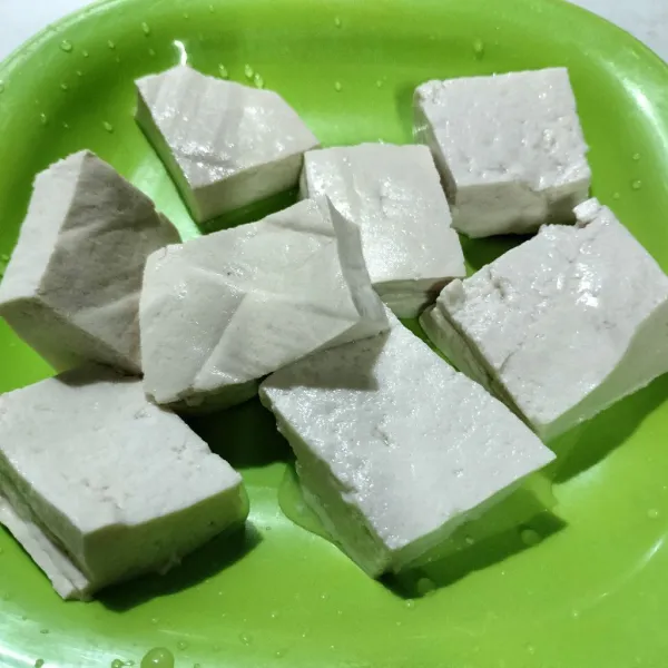 Langkah pertama cuci bersih tahu lalu potong kotak kotak.