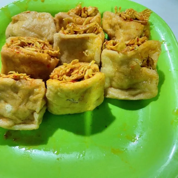 Kemudian masukkan ayam yang sudah di masak ke dalam tahu yang sudah digoreng.