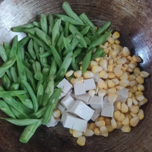 Masukkan buncis, jagung, dan tahu. Tumis hingga sayur layu.