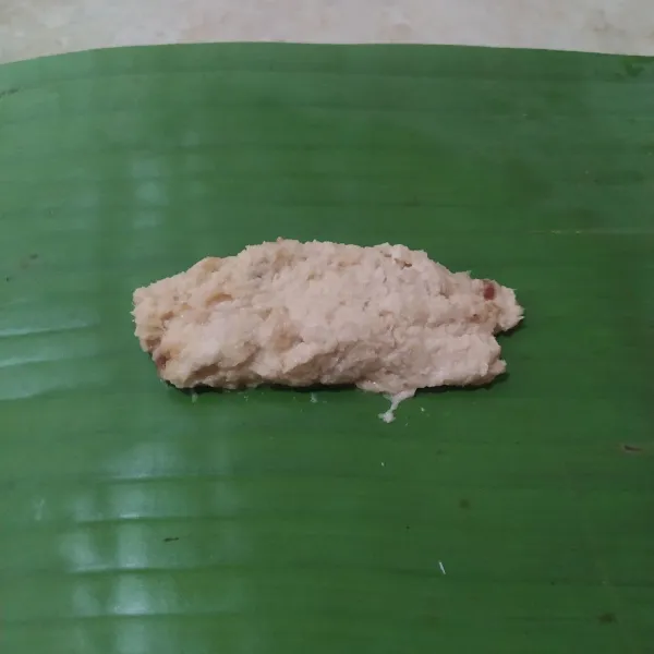 Ambil 2 sdm adonan, lalu letakkan adonan di atas daun pisang.