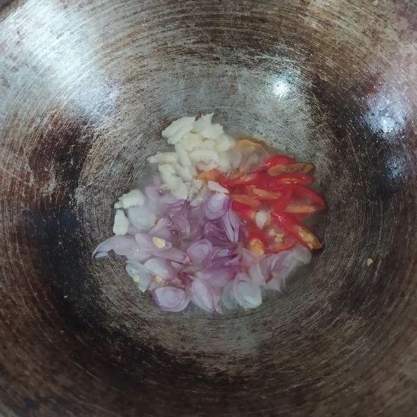 Panaskan minyak. kemudian tumis bawang merah, bawang putih, cabai merah keriting, dan cabai rawit merah hingga harum dan matang. Gunakan api sedang.