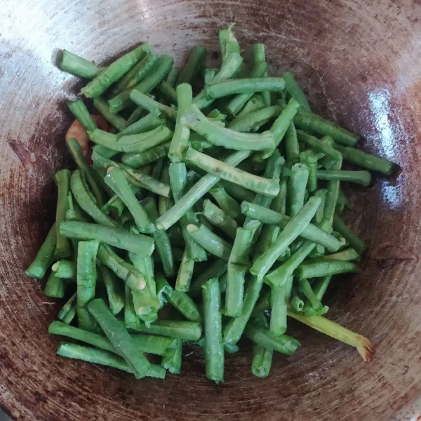 Masukkan kacang panjang, aduk rata. Tumis hingga layu.