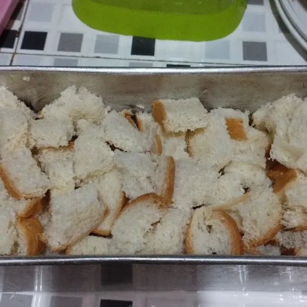 Oles loyang dg margarin.sisihkan lalu potong kotak² kecil roti tawar,lalu masukkan ke dalam loyang.