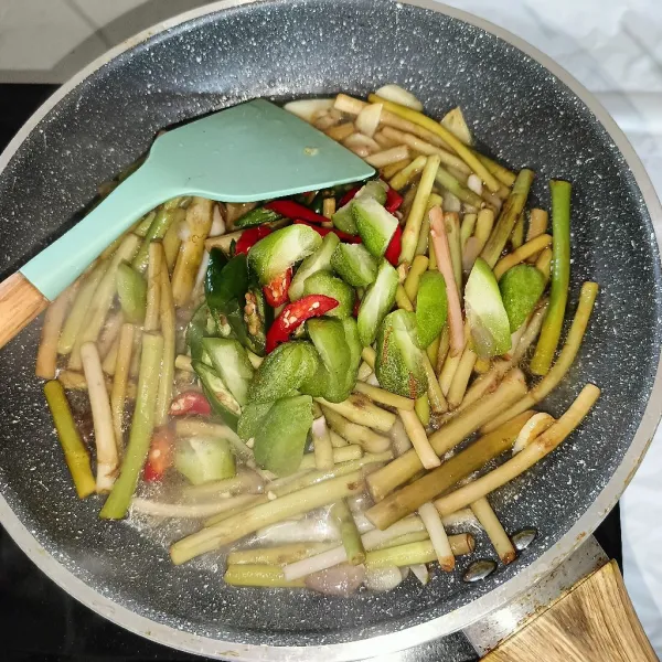 Tuang air dan tambahkan irisan belimbing wuluh dan cabai. Masak sampai sulur matang.