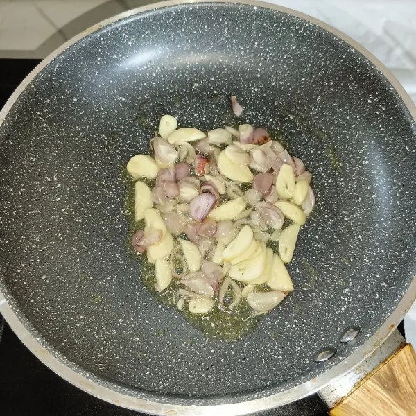 Tumis irisan bawang merah dan bawang putih sampai harum.
