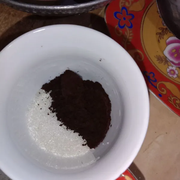 Siapkan gelas saji, masukkan gula pasir dan kopi bubuk.