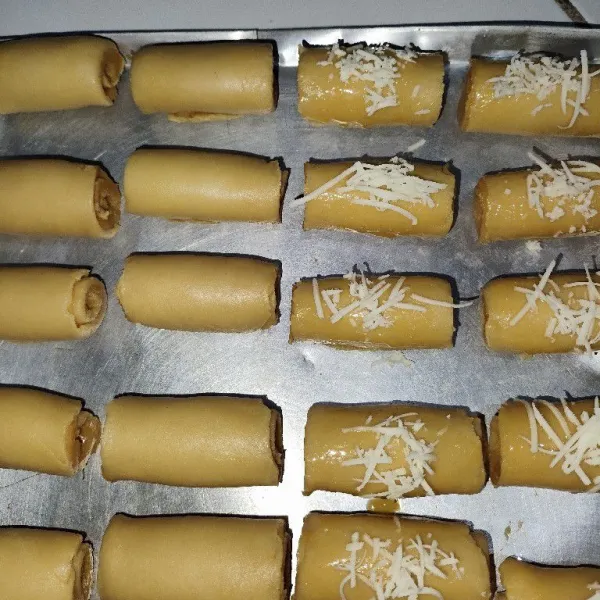 Lakukan sampai semua selesai, lalu olesi bagian atasnya dengan kuning telur dan beri taburan keju parut.