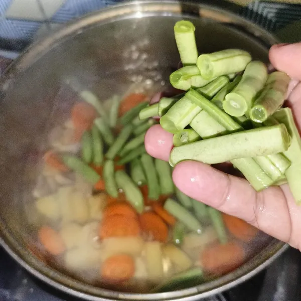 Bila sudah setengah matang, masukkan potongan buncis.