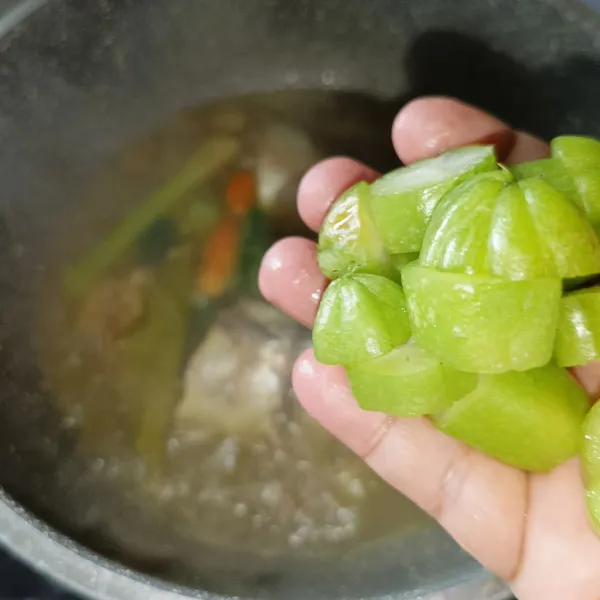 Masukkan irisan belimbing wuluh, cabai hijau, dan cabai rawit utuh.