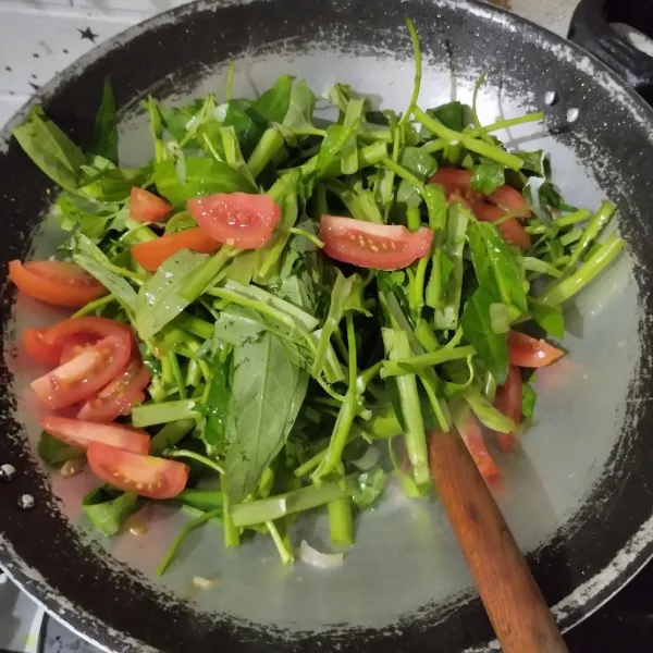 Masukkan kangkung dan tomat. Aduk rata hingga kangkung sedikit layu.