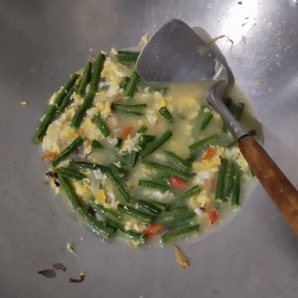 Tuang air, biarkan mendidih lalu masukkan kacang panjang. Masak hingga kacang setengah matang.