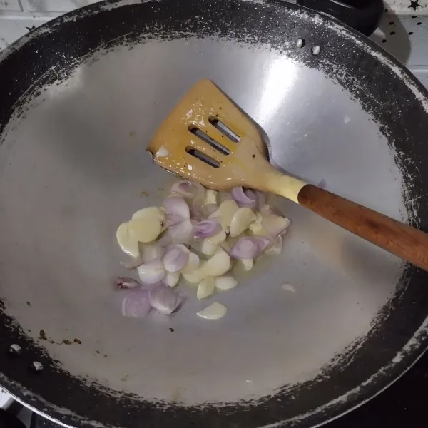 Tumis irisan bawang merah dan bawang putih hingga harum.