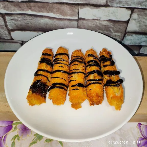 Hidangkan tape roll di atas piring, lalu beri topping coklat glaze agar lebih nikmat. Selamat mencoba! 🥰