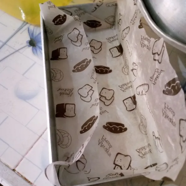 Alasi loyang dengan kertas baking, rekatkan sisinya. Tuang adonan ke dalam loyang. Panaskan oven sebelum memasukkan loyang.