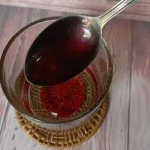 Siapkan gelas saji. Tuang sirup mawar ke dalam gelas.
