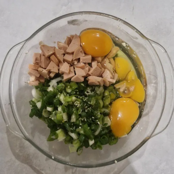 Siapkan daun bawang dan sosis yang sudah dipotong, masukkan juga telur. Kemudian, aduk rata.