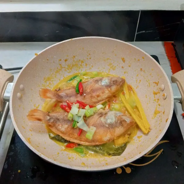 Masukkan ikan, daun bawang, cabe rawit, cabe merah, kaldu bubuk dan gula. Aduk rata.