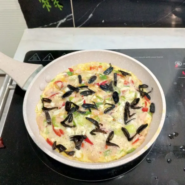 Tambahkan irisan nori di atas adonan telur.