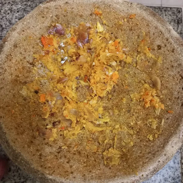 Haluskan bawang merah, bawang putih, kemiri dan kunyit.