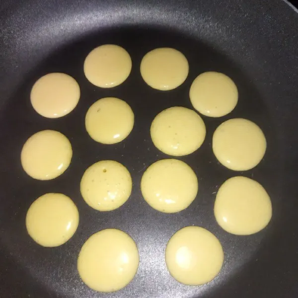 Panaskan wajan, lalu gunakan api kecil. Tuangkan adonan pancake, bentuk bulat mini.