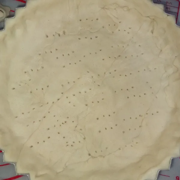 Letakkan pastry di atas cetakan, lalu tusuk dengan garpu.