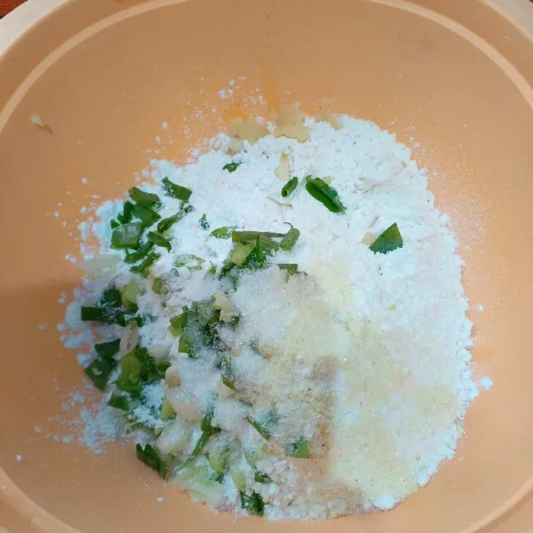 Siapkan wadah, masukkan tepung terigu, tepung tapioka, garam, kaldu bubuk, bumbu penyedap dan daun bawang. Lalu aduk rata.