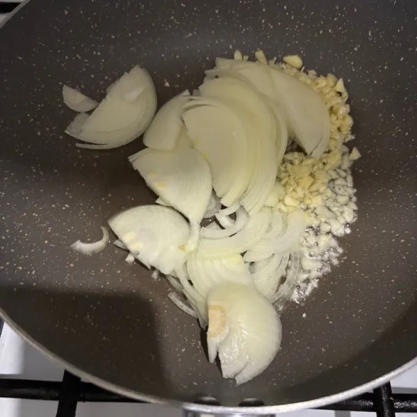 Iris-iris bawang bombay. Masukkan ke dalam wajan. Tumis hingga harum.