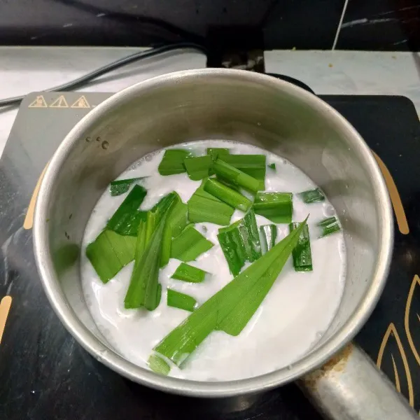 Tambahkan potongan daun pandan, masak hingga hangat. Matikan api kompor. Sisihkan.