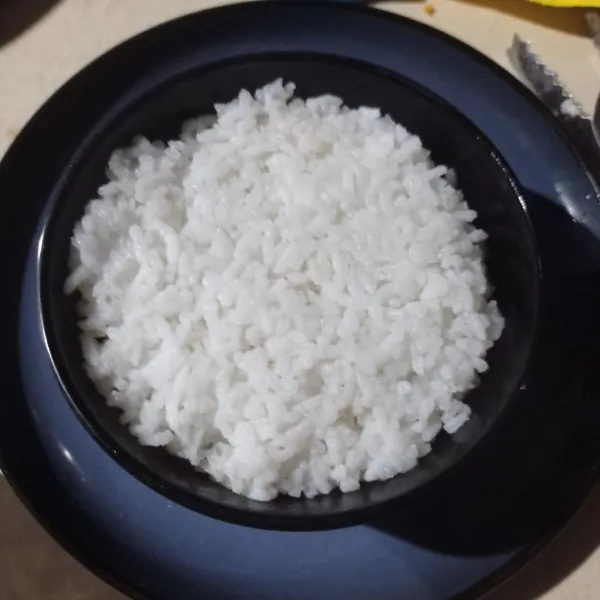Siapkan mangkok, lalu masukkan ayam suwir secukupnya. Timpa dengan nasi hangat, kemudian tekan dan ratakan.
