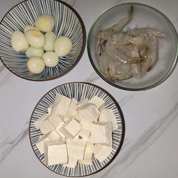 Potong dadu tahu,bersihkan udang buang kepala dan kotoran nya, kupas telur puyuh.
