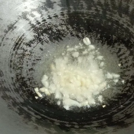 Panaskan minyak, kemudian tumis bawang putih hingga wangi.