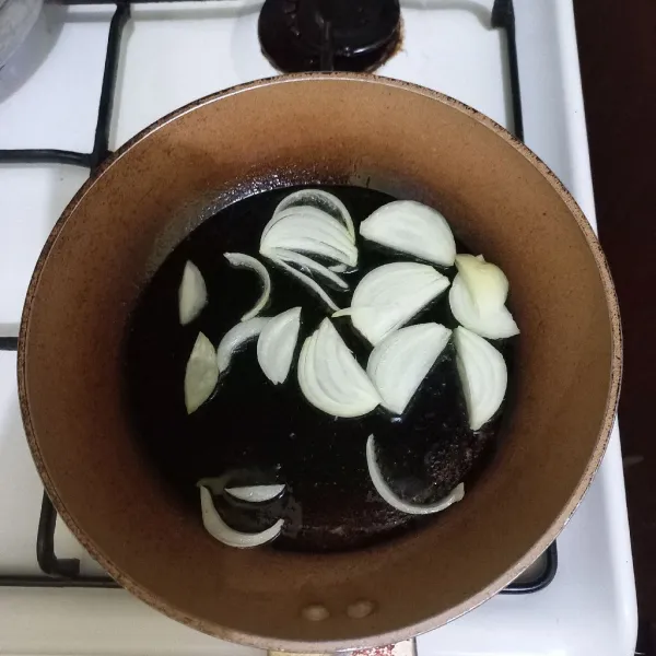 Tumis irisan bawang bombay dan bawang putih hingga harum