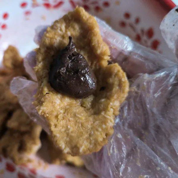 Ambil adonan secukupnya kemudian tambahkan selai coklat secukupnya, kemudian bentuk bulat.