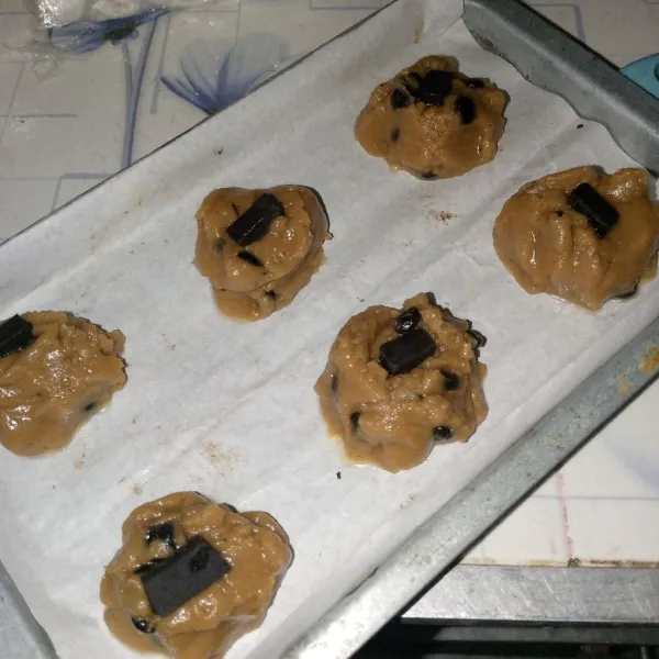 Ambil cookie secukupnya dengan sendok, letakkan berjarak di atas loyang yang sudah dilapisi baking paper. Beri topping coklat batang. Oven selama 15-20 menit api atas bawah suhu 170-175°C.