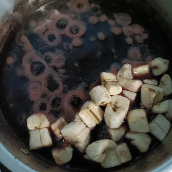 Setelah itu masak kembali, aduk-aduk terus, dan masukkan potongan pisang, gula pasir dan garam, aduk rata