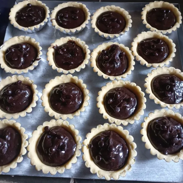 Tuang adonan ke adonan pie, lalu beri toping chocochips, diamkan 10 menit.