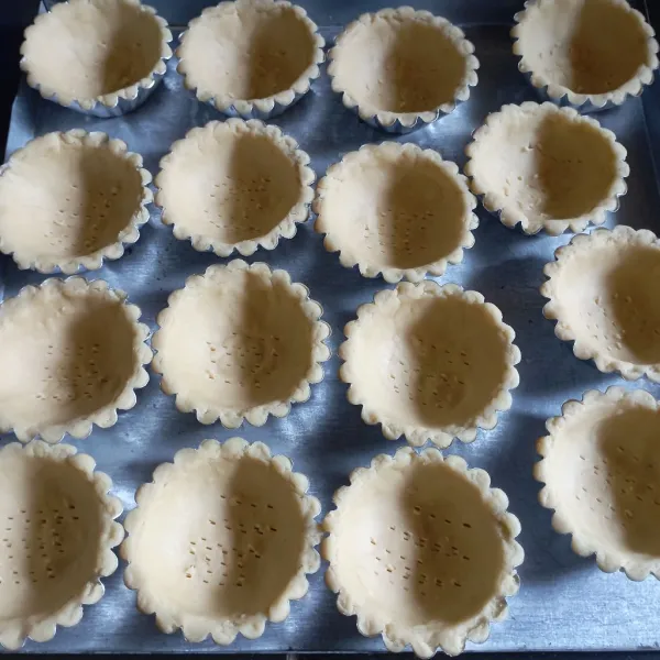 Siapkan cetakan pie, lalu cetak adonan, ratakan tusuk bagian dasar menggunakan garpu, sisihkan.