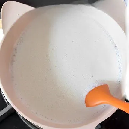 Panaskan 400 ml susu cair dalam panci dengan api kecil, tambahkan 30 gr gula pasir, aduk perlahan hingga muncul sedikit busa di permukaan. Tuangkan susu hangat ke dalam mangkuk dan biarkan dingin hingga terbentuk lapisan tipis