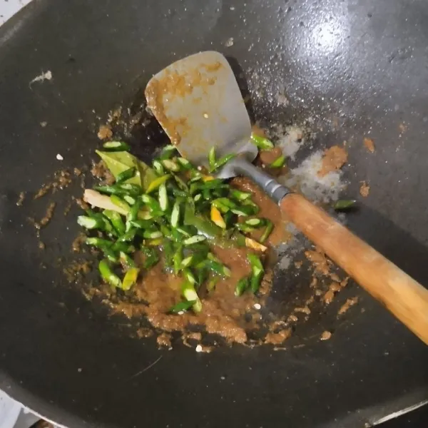 Masukkan cabai keriting hijau, tumis hingga layu.