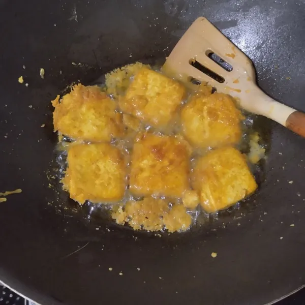 Goreng tahu setengah matang. Ciprat-cipratkan adonan tepung. Goreng hingga tahu matang.