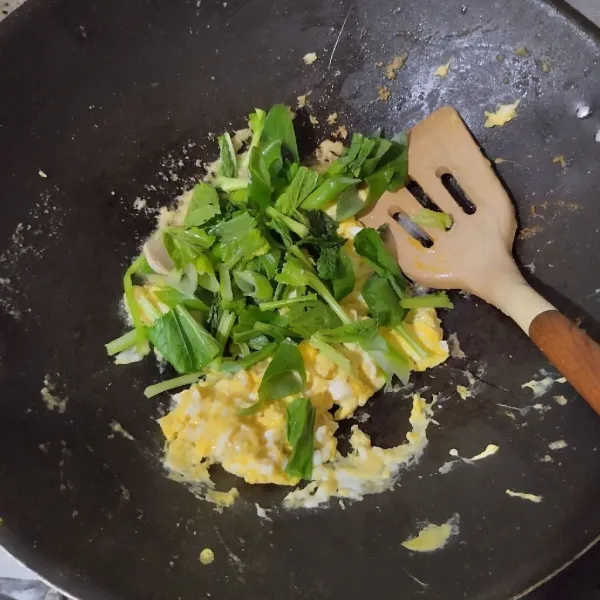 Masukkan sawi hijau dan irisan daun bawang, aduk hingga layu.