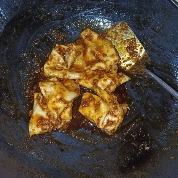Campurkan pangsit dengan bumbu, aduk rata.