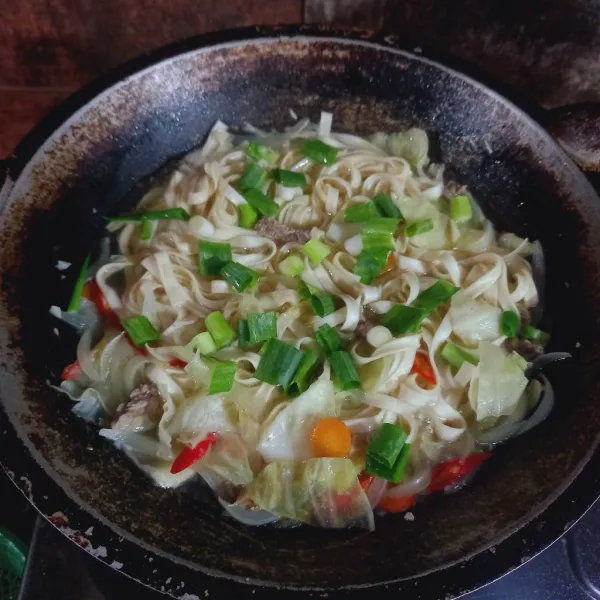 Masukkan kwetiau, tambahkan garam, penyedap rasa dan potongan daun bawang. Cek rasa.