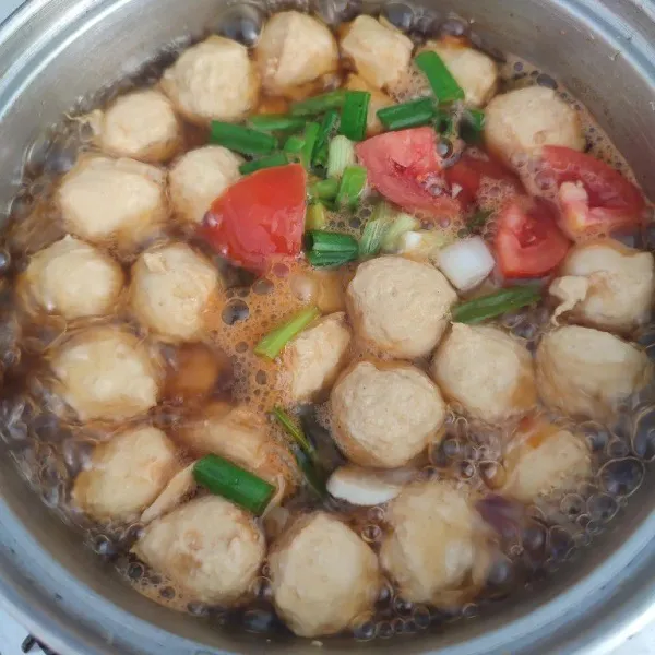 Ketika bumbu sudah meresap, masukkan potongan tomat dan irisan daun bawang. Masak sebentar, sajikan hangat.