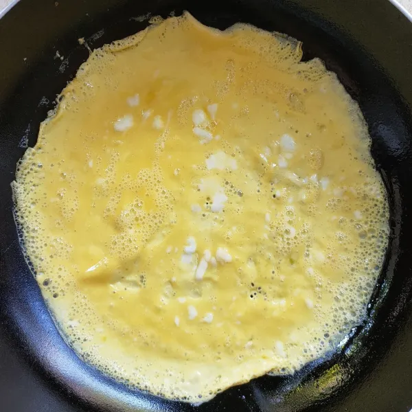 Untuk bahan pelapis, kocok telur dan garam, lalu buat telur dadar.